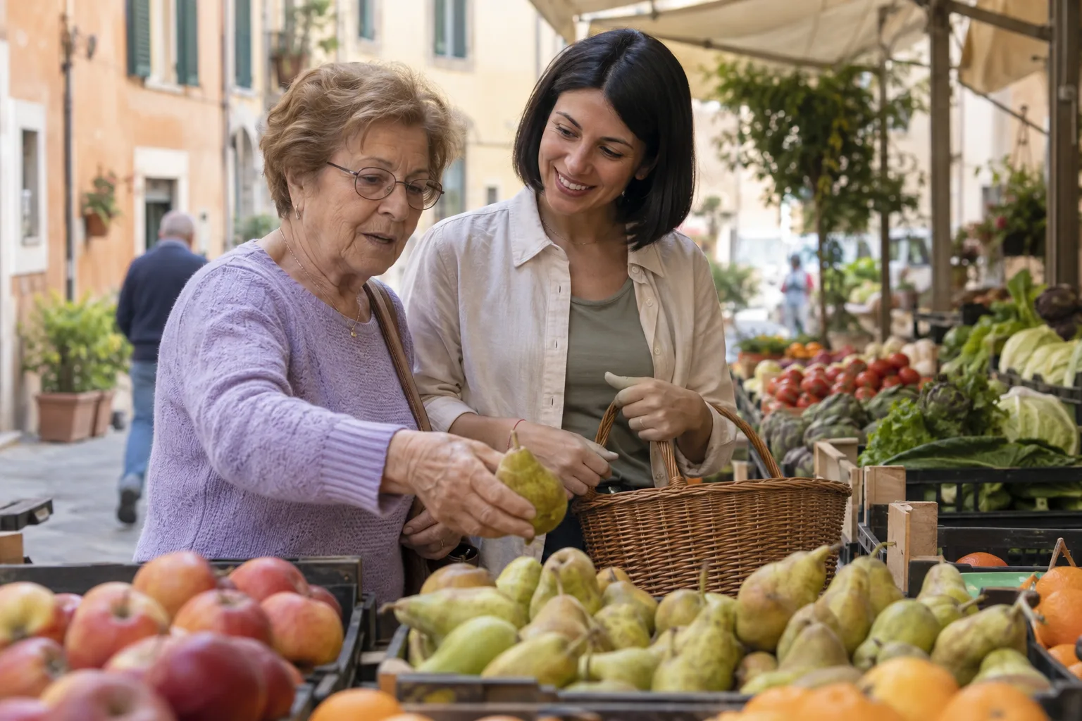 Una donna anziana sceglie la frutta al mercato insieme a un'accompagnatrice.